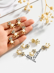Detailed view of bear pendant charm with white pearl and rhinestones held in hand