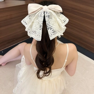 Rear view of cream lace bow hair claw clip showing 3D floral lace and satin texture