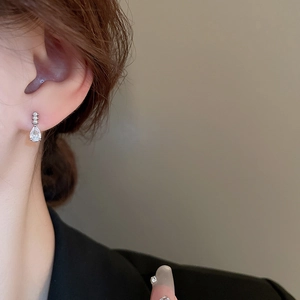 Vue rapprochée de boucles d'oreilles goutte en perles et zircone portées par un mannequin