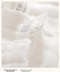 Detail of 100% cotton baby muslin towel with built-in wash label hook for easy hanging
