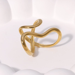 Minimalist gold abstract wavy ring with a fluid streamlined design on white surface