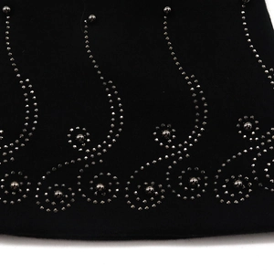 Detail of delicate rhinestone and pearl floral patterns on a black cotton beanie