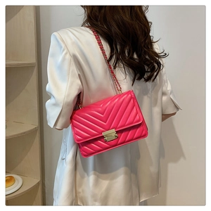 Fuchsia underarm bag featuring V-shaped quilting and a gold-tone push-lock buckle detail