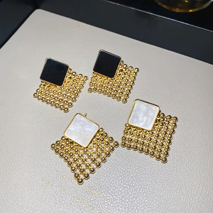 Macro view of woven geometric rhombus earrings with black and white shell texture