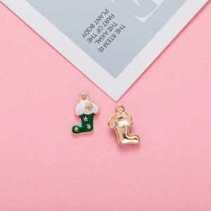 Detail showing two alloy Christmas stocking charms with green and white enamel finish