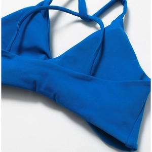 Detail of royal blue sports bra with criss-cross straps and elastic performance fabric