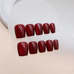 Short square press-on nails in burgundy cat-eye finish arranged on display clips