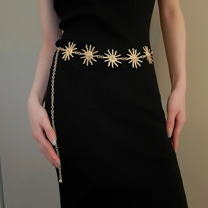 Detailopname van vintage gouden zon waist chain met reliëf op een zwarte jurk