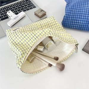 Macro shot of yellow checkered toiletry bag showing spacious interior and metal zipper