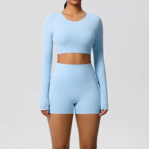 Lichtblauw tweedelig yogasetje met crop top met lange mouwen en high-waist short met zakken
