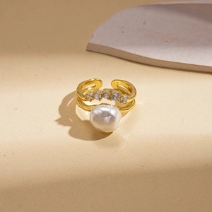 Macro detail of gold-plated double-layer ring with baroque pearl and zircon accents