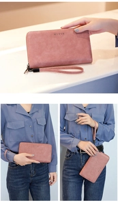 Close-up of pink long RFID zip wallet with wrist strap and textured leather finish