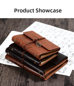 Close-up of vintage leather notebooks with embossed leaf patterns and metal pendants