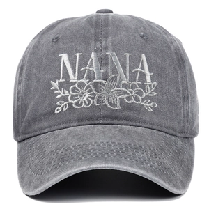 Close-up of NANA embroidery and floral patterns on washed dark gray baseball cap