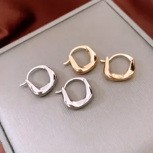 Irregular textured gold and silver hoop earrings on elegant red silk and grey display