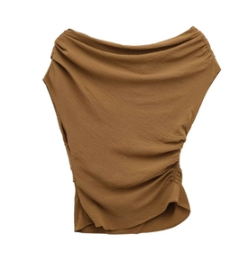 Detail of caramel draped sleeveless top with side ruching and pleated fabric texture