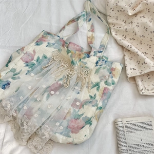 Detailed texture of linen floral tote bag with delicate white lace and mesh embroidery