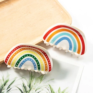 Rainbow acetate hair claw clips set with colorful patterns on a wooden tray