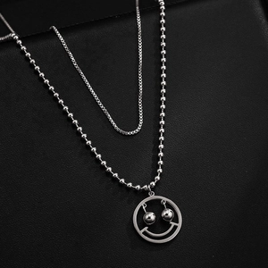 Collier double couche argenté minimaliste avec pendentif smiley mobile sur fond noir