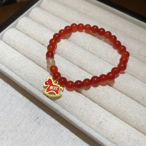 Bracelet en perles d'agate rouge avec un pendentif cheval doré porte-bonheur
