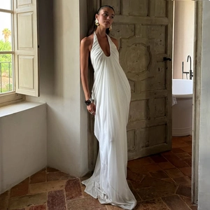 Detail of elegant white halter neck maxi dress with deep V-neck and pleated satin finish