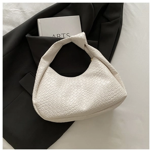 Detail of woven cream white leather bag featuring a unique knotted handle and hobo shape