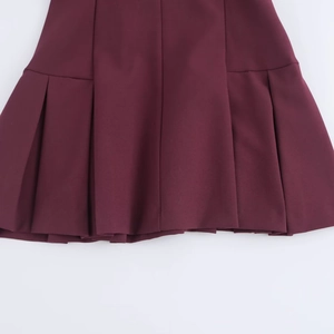 Gros plan de l'ourlet plissé d'une robe polo bordeaux de style académique épuré