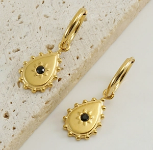 Macro shot of 18K gold-plated teardrop earrings with black gemstone and beaded trim