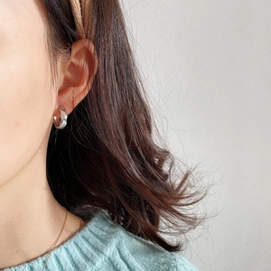 Detailed close-up of small 925 sterling silver hoop earrings with geometric pattern