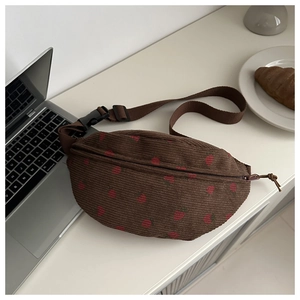 Detail of vintage brown corduroy crossbody bag with cute strawberry print on table