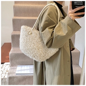 Gros plan du sac bandoulière en fausse fourrure blanche avec fine lanière et détails en métal doré
