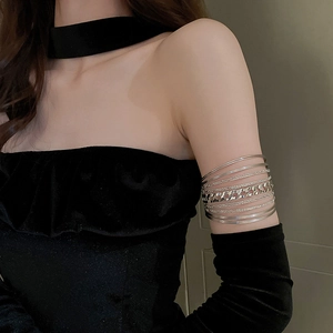Close-up of layered silver geometric upper arm cuff featuring woven chain and metal rings