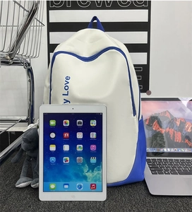 Detail showing the large capacity of the blue and white backpack with a cute plush charm