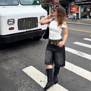 Streetstyle-Ansicht von gewaschenen schwarzen Denim-Shorts mit Leoparden-Gürtel und Stiefeln