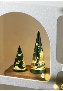 Close-up of green matte Christmas cone lights with deer and snowflake patterns