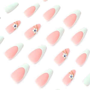 Matte pink almond press-on nails with white French tips and blue rhinestone floral accents