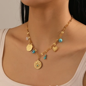 Close-up of golden necklace with heart charms, blue eye pendant, and turquoise beads