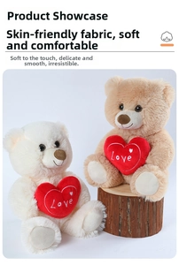 Detail of plush teddy bears in brown and cream colors holding Love embroidered hearts