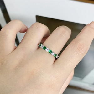 S925 sterling silver eternity ring featuring green and clear round gemstones on a finger
