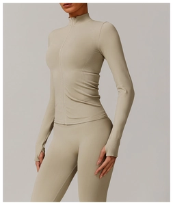 Detail of light khaki ribbed yoga jacket featuring thumbhole cuffs and a stand collar