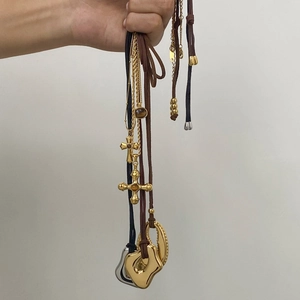 Close-up of stainless steel tiger eye necklaces with cross pendants and leather cords