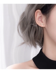 Detail view of 925 silver ball studs comparing 2.5mm and 5mm diameter sizes on ear