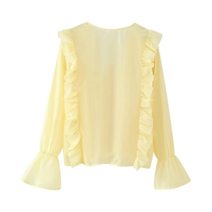 Dettaglio della camicetta in chiffon giallo chiaro con volant sul retro e maniche a campana