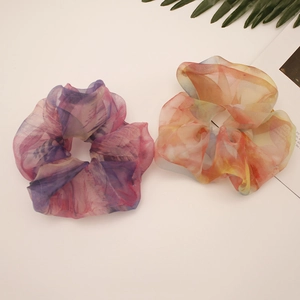 Close-up of oversized organza scrunchies in gradient pink-purple and orange-yellow colors