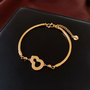 Dettagli macro del bracciale placcato oro 18k con ciondolo a zucca e chiusura a moschettone