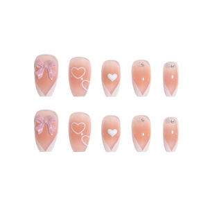 Sweet pink bow French nails with heart accents and diamonds on white background
