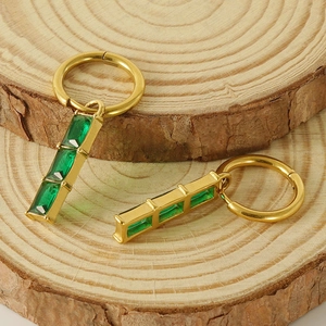 18K gold plated hoop earrings with green rectangular zircon pendants on wood base
