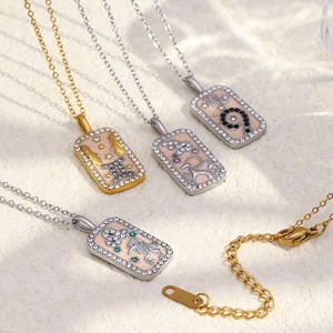 Detail of 18K gold plated zodiac pendant necklaces with enamel and sparkling crystals