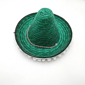 Detailed view of a green Mexican straw sombrero with white pom-pom trim for parties.