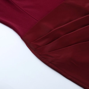 Vue détaillée d'une robe en satin bordeaux montrant les coutures et la texture plissée